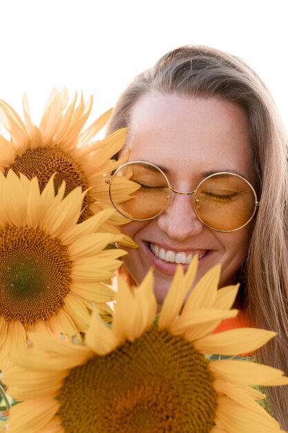 Glückliche Frau, die mit Sonnenblumen aufwirft