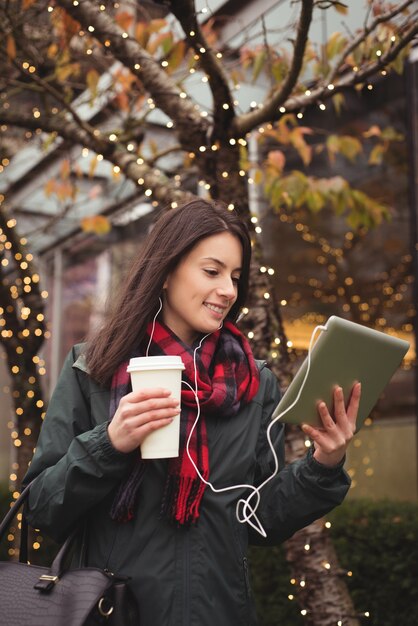 Glückliche Frau, die Musik auf Tablette hört