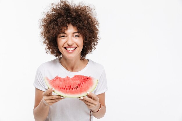 Glückliche Frau, die Scheibe einer Wassermelone hält