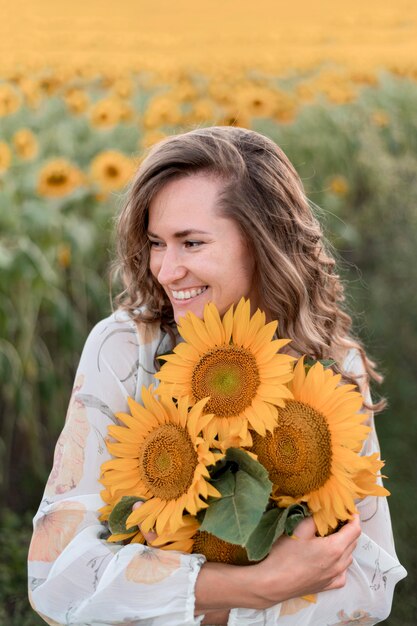 Glückliche Frau, die Sonnenblumen hält