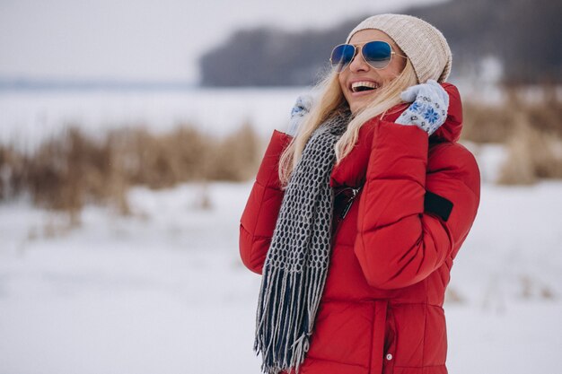 Glückliche Frau in der roten Jacke draußen im Winter