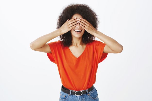 glückliche frau mit afro frisur posiert im studio