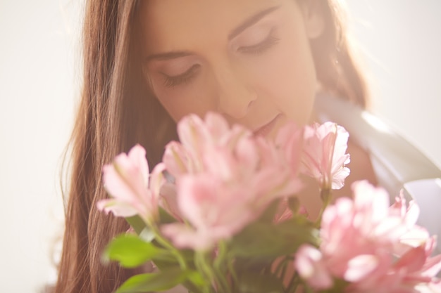 Glückliche Frau mit Blumen neben ihr Gesicht