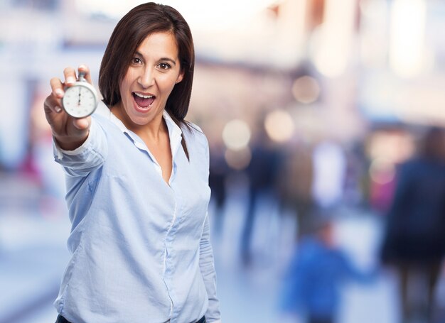 Glückliche Frau mit einer Uhr in der Hand