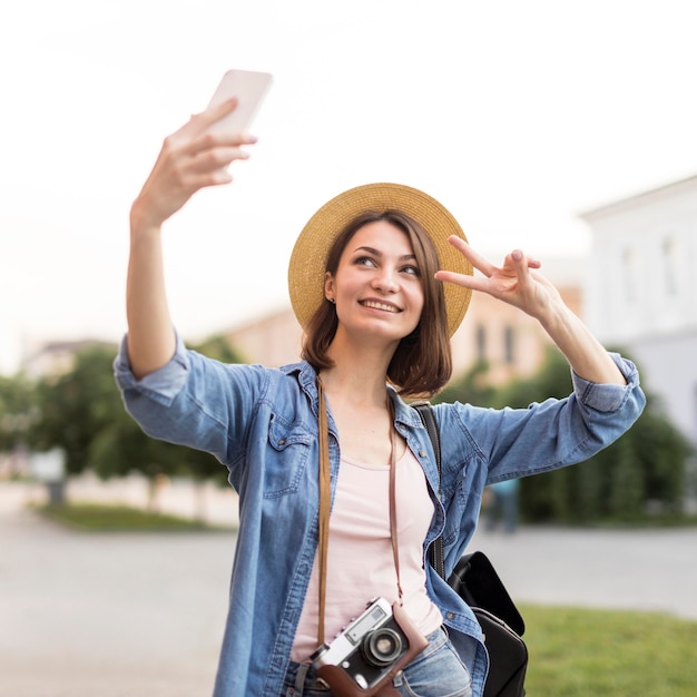 Glückliche Frau mit Hut, der selfie im Urlaub nimmt