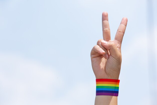 Glückliche Frau mit Regenbogenarmband LGBT.