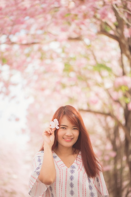 Glückliche Frau Reisende entspannen sich frei mit Kirschblüten oder Sakura Blumenbaum im Urlaub