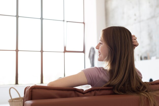 Glückliche Frau sitzt auf einer Couch