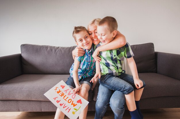 Glückliche Frau umarmt ihre Kinder am Muttertag