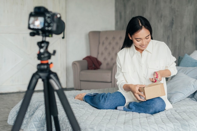 Kostenloses Foto glückliche frau unboxing beim live-streaming