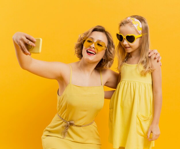 Glückliche Frau und Mädchen, die ein Selfie beim Tragen der Sonnenbrille nehmen
