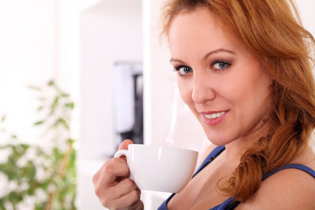 Glückliche Frau von mittlerem Alter genießen ihren Tee