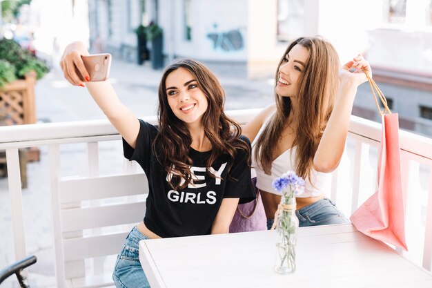 Glückliche Frauen, die selfie im Café nehmen