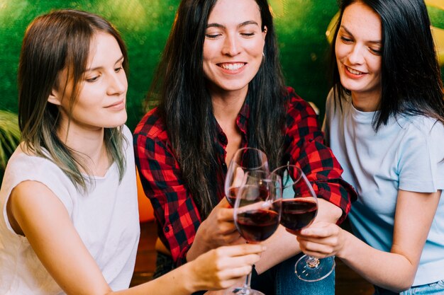 Glückliche Frauen, die Wein an der Party rösten