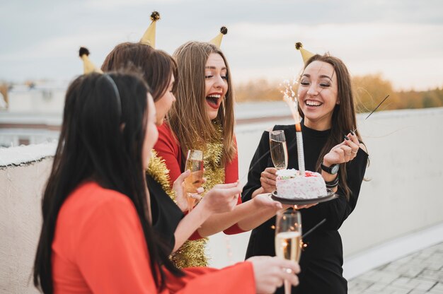 Glückliche Frauengruppe, die den Geburtstag auf der Dachspitze feiert