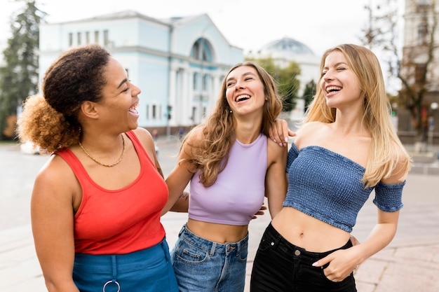 Glückliche Freunde, die auf der Straßenvorderansicht lachen