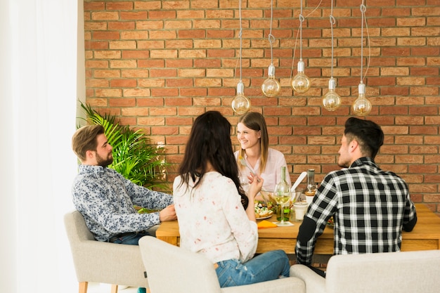 Glückliche Freunde, die auf Lehnsesseln sitzen