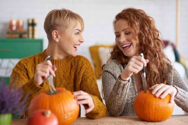 Glückliche Freunde, die Dekorationen für Halloween vorbereiten