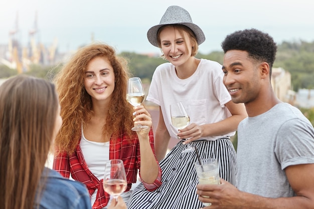 glückliche Freunde, die stilvolle Kleidung tragen, die College-Abschluss feiert