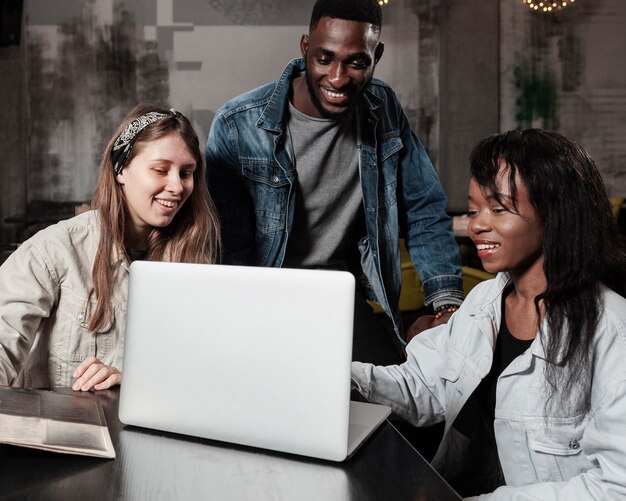 Glückliche Freunde, die zuhause Laptop betrachten