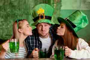 Kostenloses Foto glückliche freunde feiern zusammen st. patricks tag an der bar mit getränken