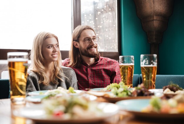 Glückliche Freunde sitzen im Café beim Essen und Trinken von Alkohol