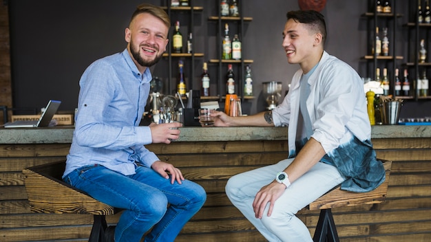 Glückliche Freunde, welche die Getränke im Restaurant genießen