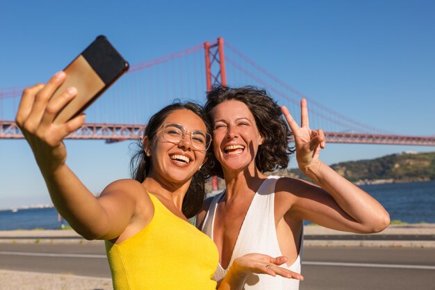 Glückliche Freundinnen, die für selfie aufwerfen