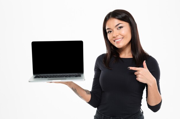 Glückliche junge asiatische Dame, die Anzeige des Laptops zeigt