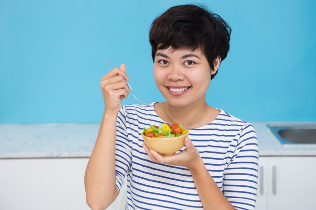 Glückliche junge asiatische Frau Essen Gemüsesalat