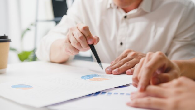 Glückliche junge asiatische Geschäftsleute und Geschäftsfrauen, die Brainstorming-Ideen treffen