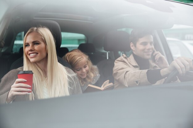 Glückliche junge Familie im Auto