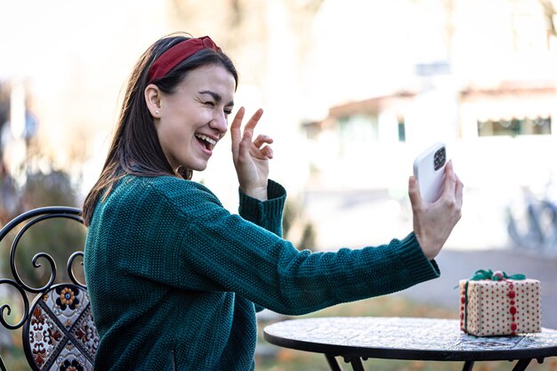 Glückliche junge Frau, die ein Selfie macht, das sich auf den Weihnachtsfeiertag vorbereitet