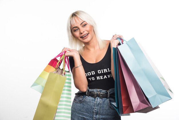 Glückliche junge Frau, die Einkaufstaschen auf weißem Hintergrund hält. Hochwertiges Foto