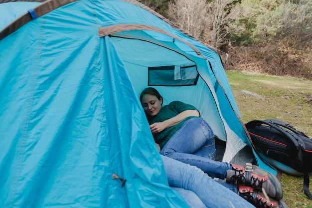 Glückliche junge Frau in einem blauen Zelt
