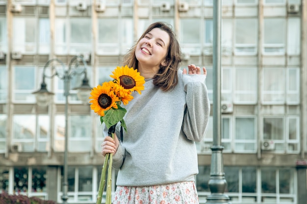 Glückliche junge Frau mit einem Strauß Sonnenblumen