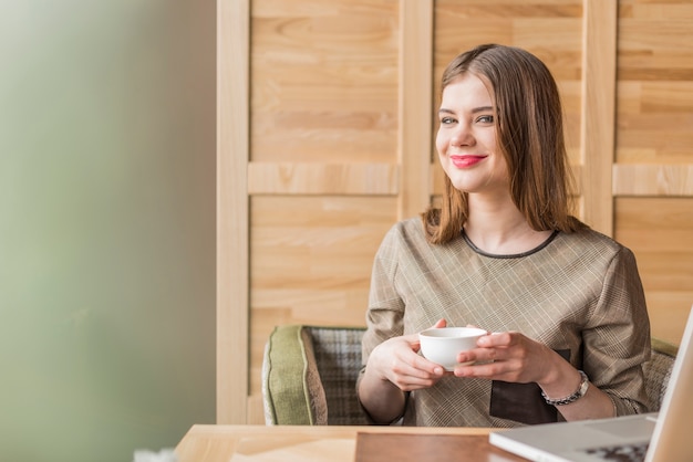 Kostenloses Foto glückliche junge frau mit einer tasse tee