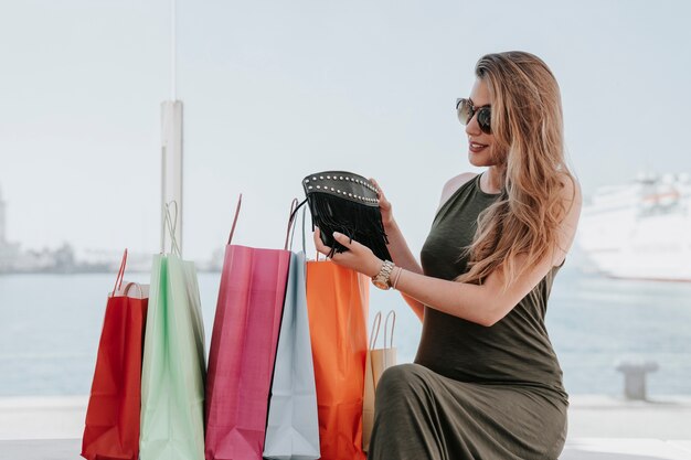 Glückliche junge Frau mit ihrer neuen Handtasche