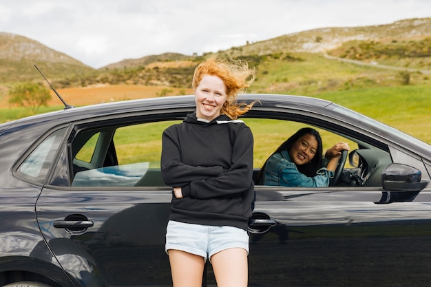 Kostenloses Foto glückliche junge frauen, die mit dem auto anreisen