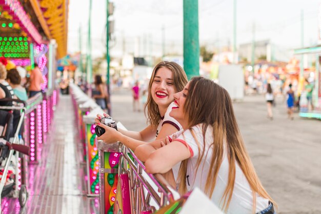 Glückliche junge Freunde im Vergnügungspark