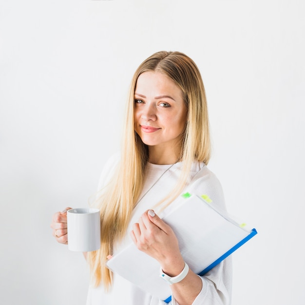 Kostenloses Foto glückliche junge geschäftsfrau mit der tasse tee getrennt auf weißem hintergrund