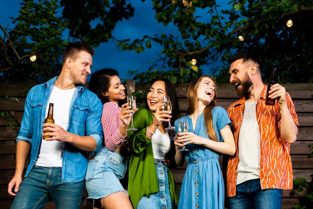 Glückliche junge Leute zusammen mit alkoholischen Getränken