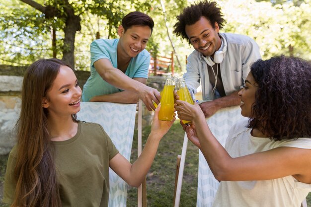 Glückliche junge multiethnische Freunde Studenten im Freien, die Saft trinken