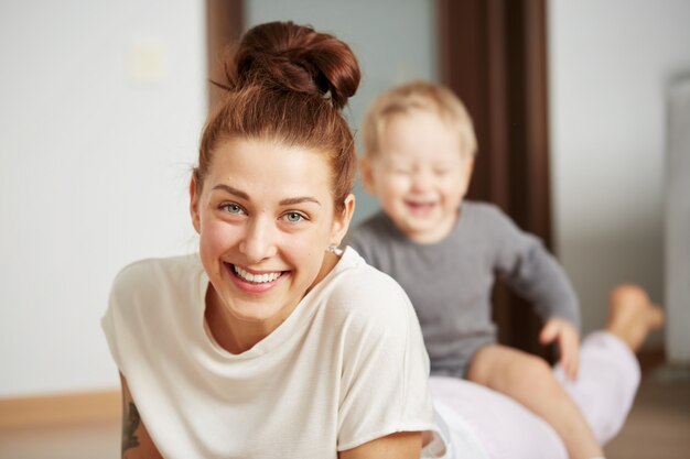 Glückliche junge Mutter mit kleinem Sohn zu Hause