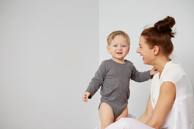 Glückliche junge Mutter mit kleinem Sohn zu Hause