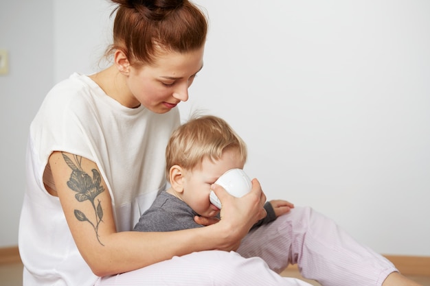 Glückliche junge Mutter mit kleinem Sohn zu Hause