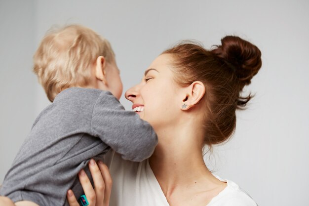 Glückliche junge Mutter mit kleinem Sohn zu Hause