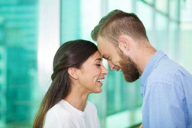 Glückliche junge Paar von Angesicht zu Angesicht zu lachen