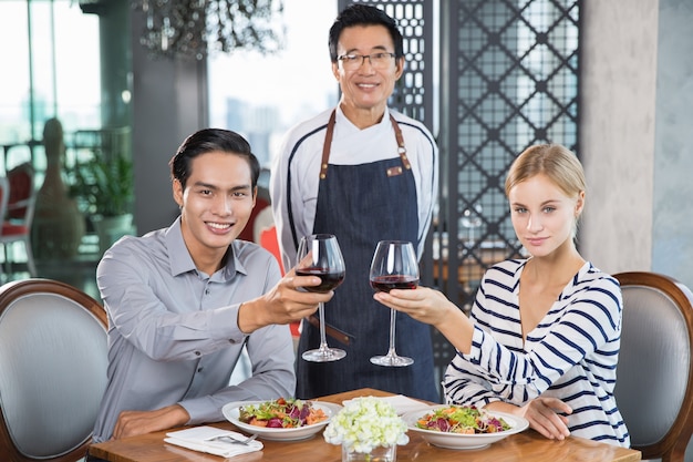 Glückliche Junge Paare, die Rotwein trinkt in Restaurant