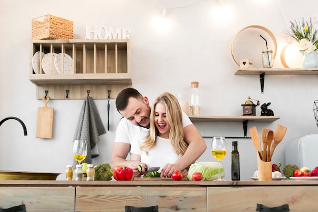 Glückliche junge Paare, die zusammen kochen